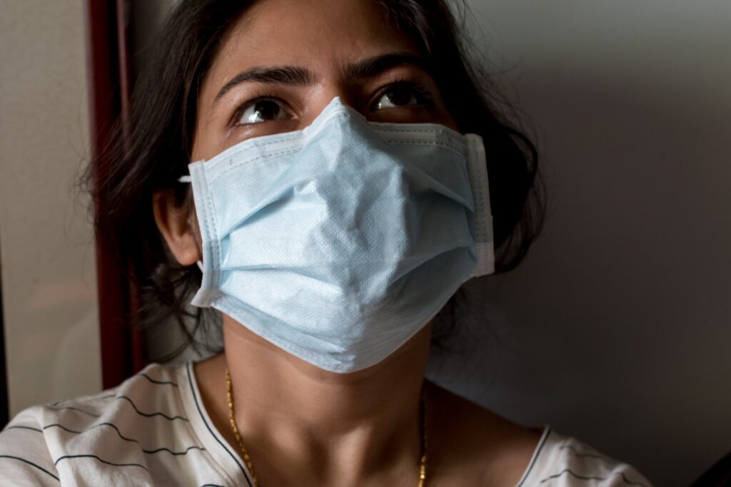 A mental health pandemic is following COVID-19, which required this woman to wear a mask.